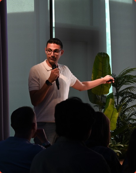 Abanoub Awny speaking on stage at an Unblind UX event